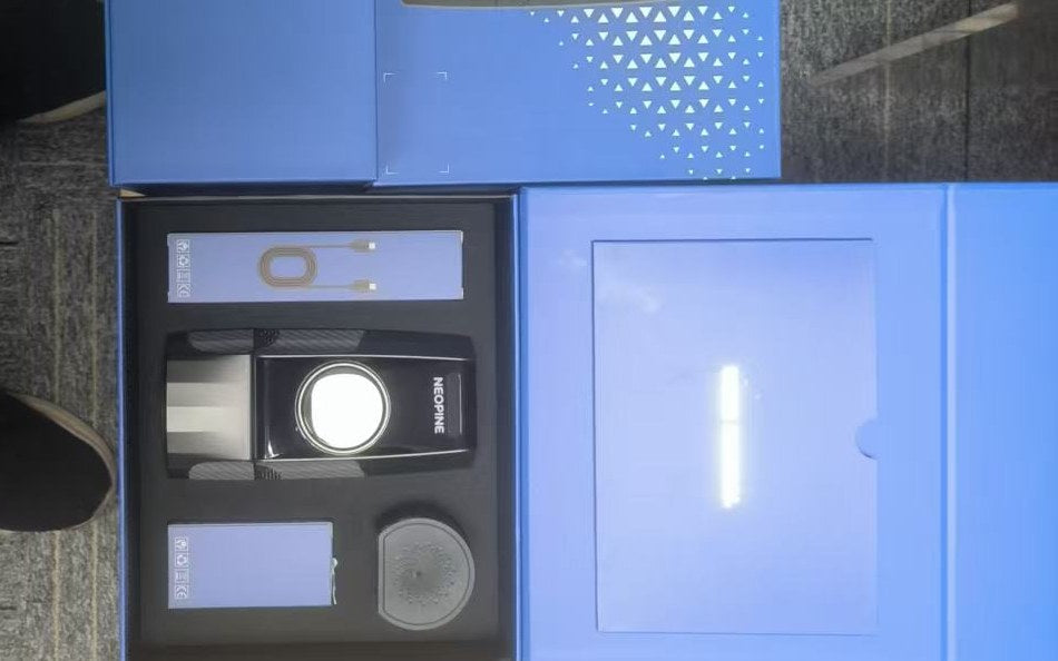 NEOPINE Pro 2026 kit opened after delivery, with the device, battery, charger and manual in their cut-outs